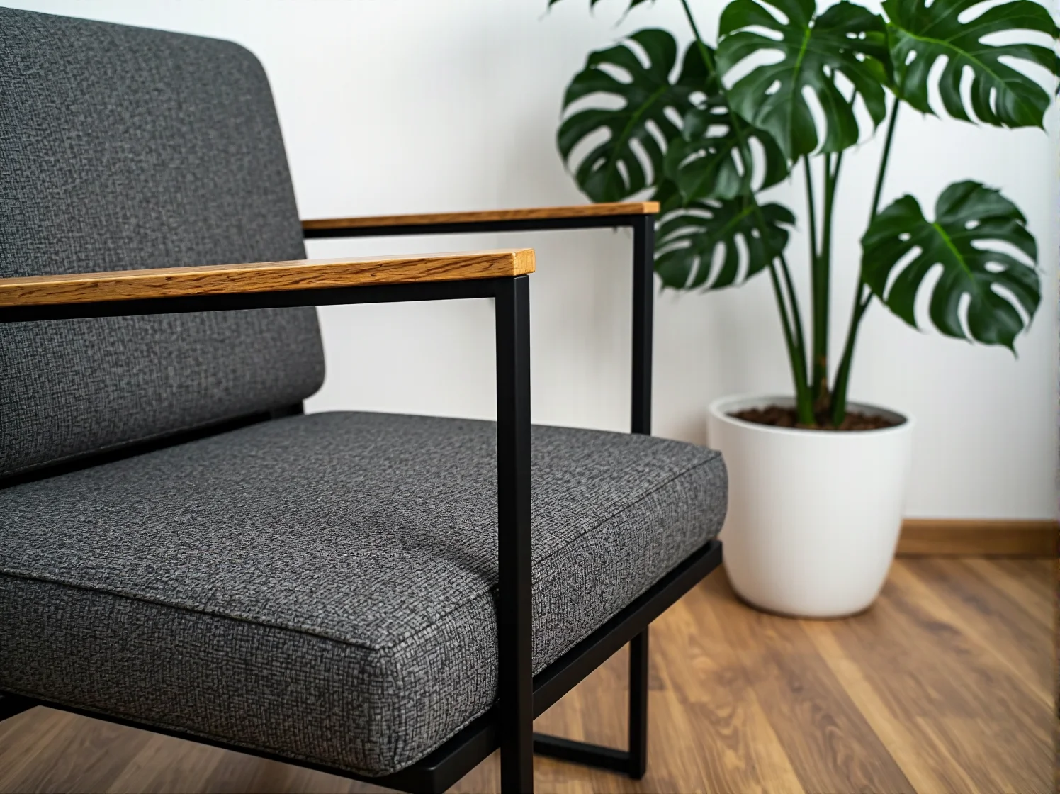 Szary fotel wypoczynkowy o ponadczasowym designie w minimalistycznym wnętrzu.